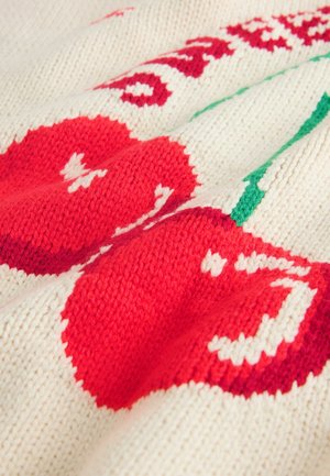 Strikket stof i cremefarve med røde kirsebær og grønne blade. Synlig struktur fra syninger, med et mønster af frugt og dekorative accenter.