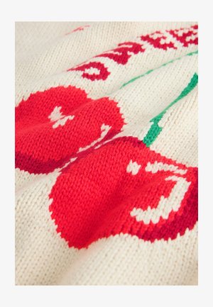 Dzianina w kremowym kolorze z czerwonymi wiśniami i zielonymi liśćmi. Widoczna faktura przeszyć, z wzorem owoców i ozdobnych akcentów.