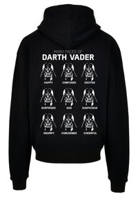 Svart hettegenser med ni illustrasjoner av Darth Vaders ansikt, hver med en annen følelse, med hvite tekstetiketter under hvert bilde.