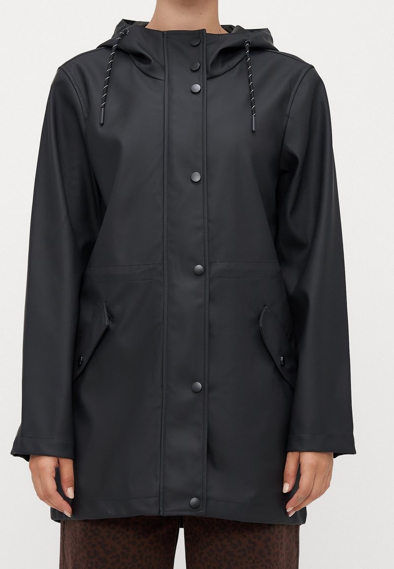 Veste de pluie noire imperméable avec capuche, fermeture à boutons-pression à l'avant et poches latérales. Texture lisse avec cordons de serrage pour un ajustement personnalisé.