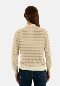 Suéter de rayas beige con un acabado suave y texturizado, puños y dobladillo acanalados. Presenta bandas horizontales en tonos beige claro y oscuro.
