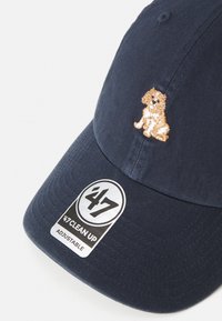 Marineblaue Baseballmütze mit verstellbarem Rücken. Sie verfügt über eine goldene Pailletten-Stickerei eines Hundes an der Seite und ein '47 Clean Up'-Tag am Schirm.