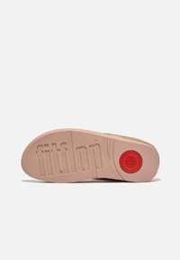 Fitflop sandaal zool, lichtbeige rubber met een gestructureerd oppervlak. Voorzien van een prominente rode cirkelvormige accent en het emblematische merklogo.