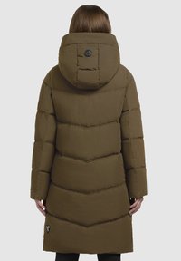 Langer olivgrüner Puffer-Mantel mit Kapuze, der ein Chevron-Steppdesign, Fronttaschen und ein kreisförmiges Logo auf der Rückseite aufweist.