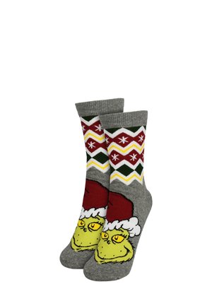 Calze grigie con un motivo natalizio, che presentano un'illustrazione del Grinch che indossa un cappello rosso, accompagnata da motivi a zigzag multicolori e fiocchi di neve.