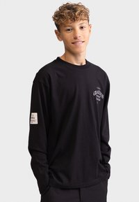 Zwarte longsleeve shirt van katoen met een ronde halslijn, voorzien van een logo-opdruk en een klein stoffen label op de linkermouw.
