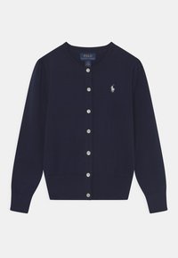 Navy sininen neulotun cardigan, jossa on pyöreä kaula-aukko, pitkät hihnat, nappikiinnitys, ribbireunus ja pieni kirjailtu logo rinnassa.