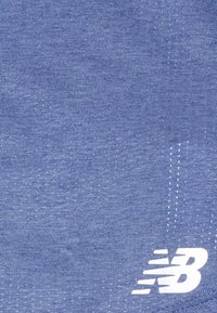 Tessuto blu testurizzato con un logo New Balance bianco nell'angolo in basso a destra, caratterizzato da sottili linee diagonali in tutto il tessuto.