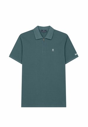 Polo de manga corta verde oscuro con cuello con cremallera, pequeño logo blanco bordado en el pecho y nombre de la marca en la manga izquierda.