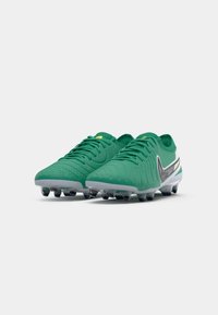 Green soccer cleats with a structured upper, textured surface, gray sole, black and white accents, and six conical studs for traction.