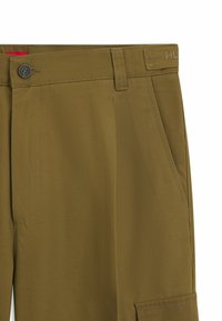 Olive green trousers with front pockets, a button closure, and stitched details. Includes a rear pocket and subtle brand embroidery on waistband.