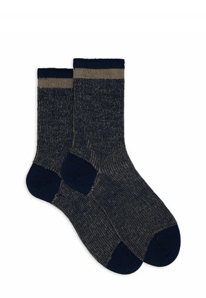 Marineblaue Socken mit strukturiertem Strick, ausgestattet mit einem kontrastierenden hellbeigen Bündchen. Abgerundete Zehenpartie und verstärkte Ferse für zusätzliche Haltbarkeit.