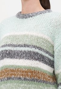 Texturierter Strickpullover mit horizontalen Streifen in Hellgrün, Grau, Braun und Creme sowie einem runden, grauen Rippkragen.