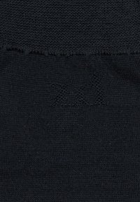 Schwarzer Strickstoff mit glatter Textur. Verfügt über einen ausgefransten Rand und subtile gestickte Details in Form von "XX" in der Nähe der Oberkante.
