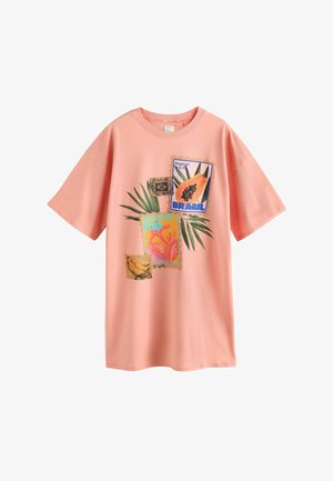 Lyserød T-shirt med farverige brasilianske tema-frimærker, palmeblade, en papaya og teksten "Strande i Rio" på fronten.