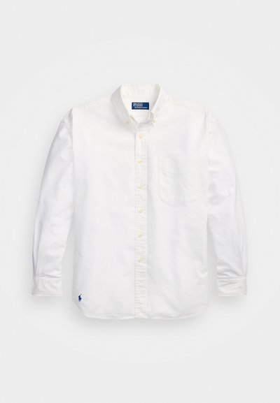 Camisa blanca de algodón de manga larga con cuello abotonado, bolsillo en el pecho izquierdo y un pequeño logo azul en la parte inferior izquierda.