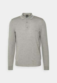 Polo gris à manches longues en tissu doux, avec un col, trois boutons et un logo discret sur la poitrine.