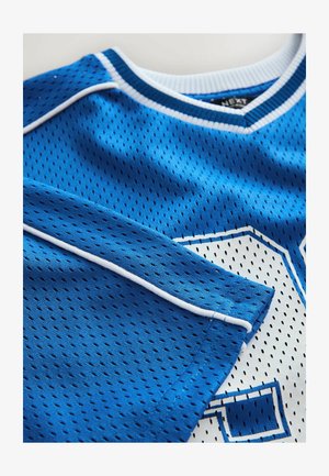 Modrý športový dres s sieťovanou textúrou, s bielymi detailmi a veľkým bielym číslom na prednej strane. Žebrovaný golier a kontrastné švy.