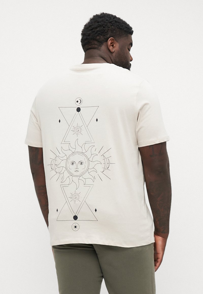 Beige Baumwoll-T-Shirt mit einem schwarzen geometrischen Sonnen- und Mondmotiv auf dem Rücken, mit dreieckigen Elementen und detaillierten Linien.