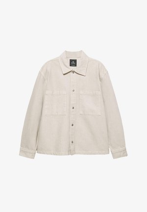 Vaaleanbeige napp closure -takki pehmeästä kankaasta, jossa on terävä kaulus, kaksi rintataskua ja pitkät hihat. Minimalistinen muotoilu.