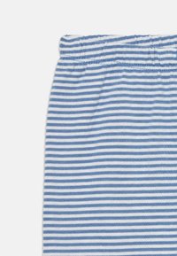 Tissu rayé horizontal bleu et blanc avec une ceinture élastique, probablement une partie d'un vêtement.
