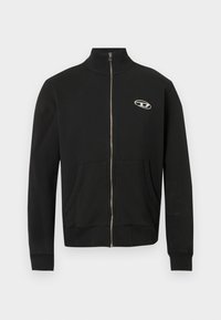 Giacca nera con cerniera frontale realizzata in tessuto morbido, con collo alto, tasche frontali, polsini a costine e un piccolo logo sul petto sinistro.