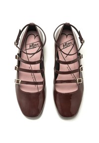 Chaussures en cuir verni bordeaux à bouts carrés, dotées de trois sangles étroites et de boucles dorées ; semelles intérieures roses avec un logo en forme de cœur.