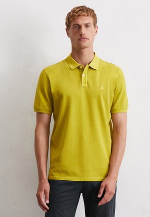 Heldere gele polo met een kraag, korte mouwen en een drieknoopsluiting. Subtiel logo op de linkerborst. Zachte katoenstof.
