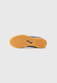Semelle de chaussure avec une surface en caoutchouc gomme texturé, présentant un motif en zigzag et un détail circulaire, de couleur bleu marine.