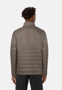 Giacca imbottita, verde olivo, finitura lucida, colletto alto, cuciture orizzontali, texture liscia, maniche lunghe, design minimalista, senza branding visibile.