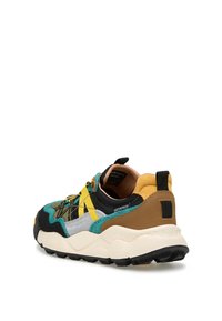 Sneaker imperméable avec un mélange de suede noir, gris, teal et jaune, une semelle blanche épaisse et des accents beiges contrastants.