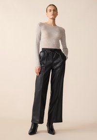 Gray long-sleeve top paired with black faux leather wide-leg pants featuring an elastic waistband and a tie detail.
