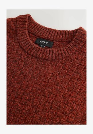 Knit sweater in a rich red color with a textured pattern. Features a ribbed crew neckline and a label reading "NEXT" and size "M."