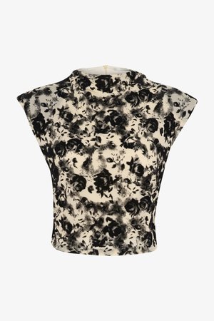 Top corto a fiori in bianco e nero con spalle larghe, scollatura rotonda e texture del tessuto liscia. Dettaglio con chiusura a zip sul retro.
