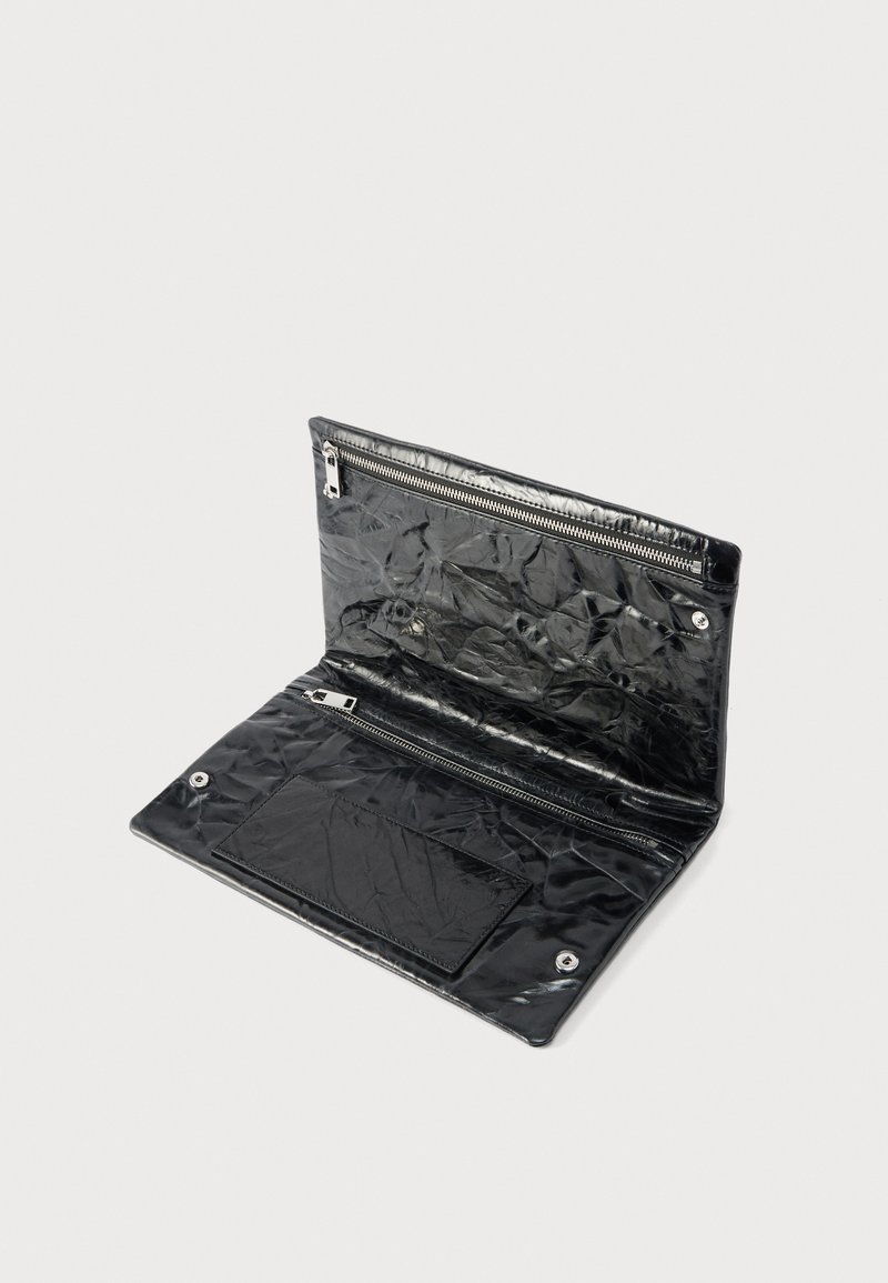 Sort krøllet læderpung åben, der viser to lynlåslommer og trykknapslukninger på en ensfarvet lys baggrund.