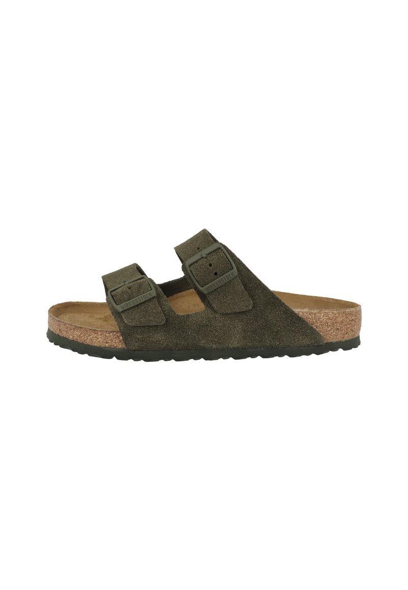 Olivgrüner Wildleder-Sandalette mit zwei Riemen, verstellbaren Schnallen und Korkfußbett, seitlich auf einem weißen Hintergrund dargestellt.