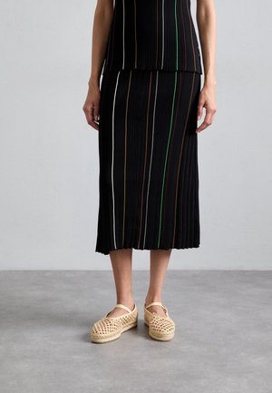 Ensemble deux pièces noir côtelé avec des rayures verticales colorées. Comprend une jupe longue au genou et des chaussures en toile plates à enfiler avec une finition naturelle.