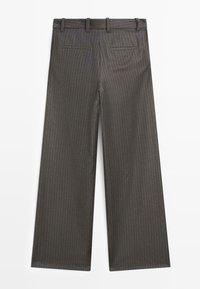Pantaloni a gamba larga in tessuto grigio scuro con sottili righe. Presentano vita con passanti per cintura e due tasche posteriori. Tessuto liscio.