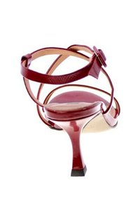 Sandal con tacchi alti in vernice rossa, con cinturini incrociati e dettaglio decorativo a forma di bottone. Caratterizzato da un tacco sottile e punta quadrata.