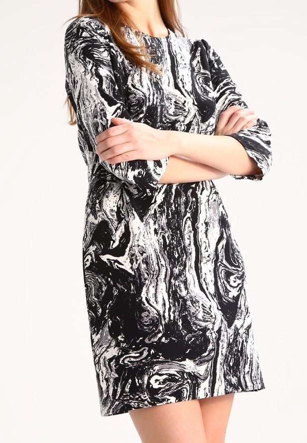 Šaty s krátkým rukávem s černobílým mramorovaným vzorem, rovného střihu a hladké tkaniny, dosahující do poloviny stehna.
