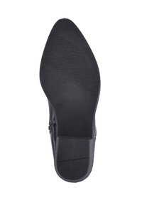 Suela de zapato negra con diseño de punta afilada, tacón plano, superficie texturizada y estrías horizontales para mayor agarre. Sin marcas visibles ni detalles adicionales.