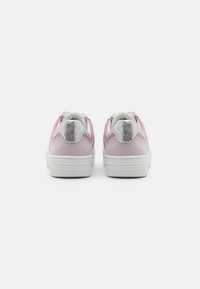 Pink suede sneakers with white rubber soles, featuring silver accents. The back showcases a heart-shaped design on each heel.