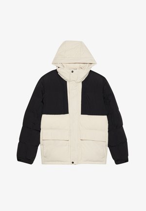 Chaqueta acolchada con una sección superior negra y una sección inferior crema, con capucha y dos bolsillos frontales. Tejido texturizado y cierre a presión.