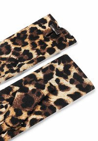 Löwenmusterstoff in Braun- und Schwarztönen, mit einer strukturierten Oberfläche und einem kleinen braunen Akzentstück oben.