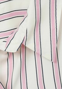 Cotton fabric with pink and navy vertical stripes. Features a smooth texture and fold in the collar area, highlighting stitching details.