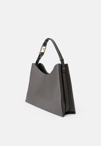 Sac à main en cuir gris avec une forme structurée, un dessus incurvé et une bandoulière amovible avec des détails en métal doré. Finition Texturée.