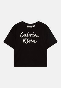 Camiseta cortada negra de algodón, con un logotipo en cursiva blanco "Calvin Klein" en el centro, con un cuello redondo y mangas cortas.