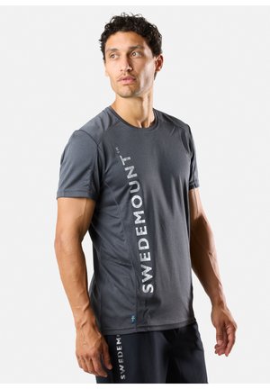 Grå T-shirt med korte ærmer til sportsbrug, med logoet "SWEDEMOUNT" trykt vertikalt i hvidt på siden. Fremstillet af letvægts, tekstureret stof.