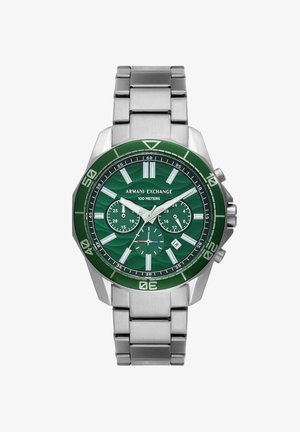 Reloj cronógrafo con esfera verde y correa de acero inoxidable plateado, que presenta una superficie con patrón, indicador de fecha y marcadores horarios luminosos.