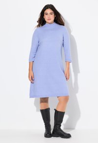 Abito lavorato a maglia blu chiaro con colletto alto e maniche a tre quarti, caratterizzato da una vestibilità rilassata e lungo fino a metà polpaccio, abbinato a stivali neri al ginocchio.
